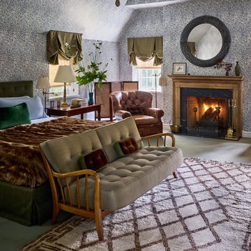 Cozy bedroom with vintage decor, featuring a fireplace and seating area. Cozy bedroom with vintage decor, featuring a fireplace and seating area.