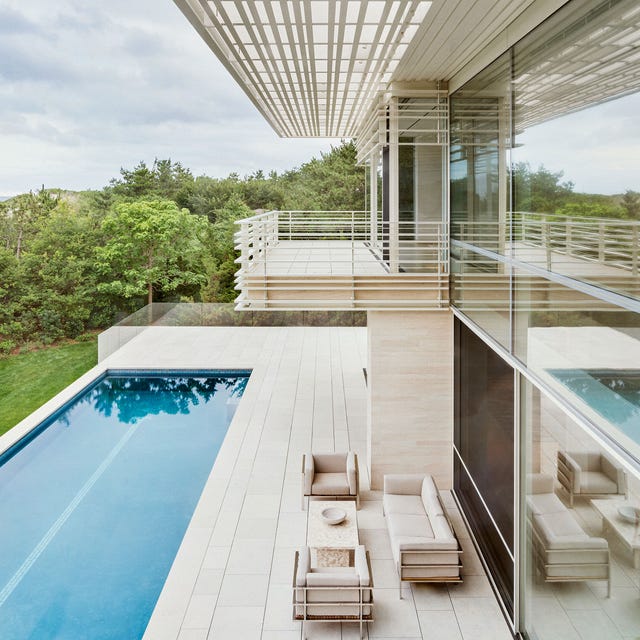 The A-List 2024 - ELLE DECOR a modern house with a pool and white furniture