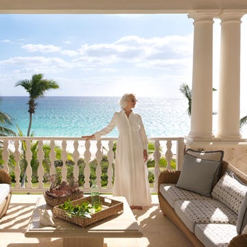 A serene balcony view overlooking the ocean with outdoor seating.