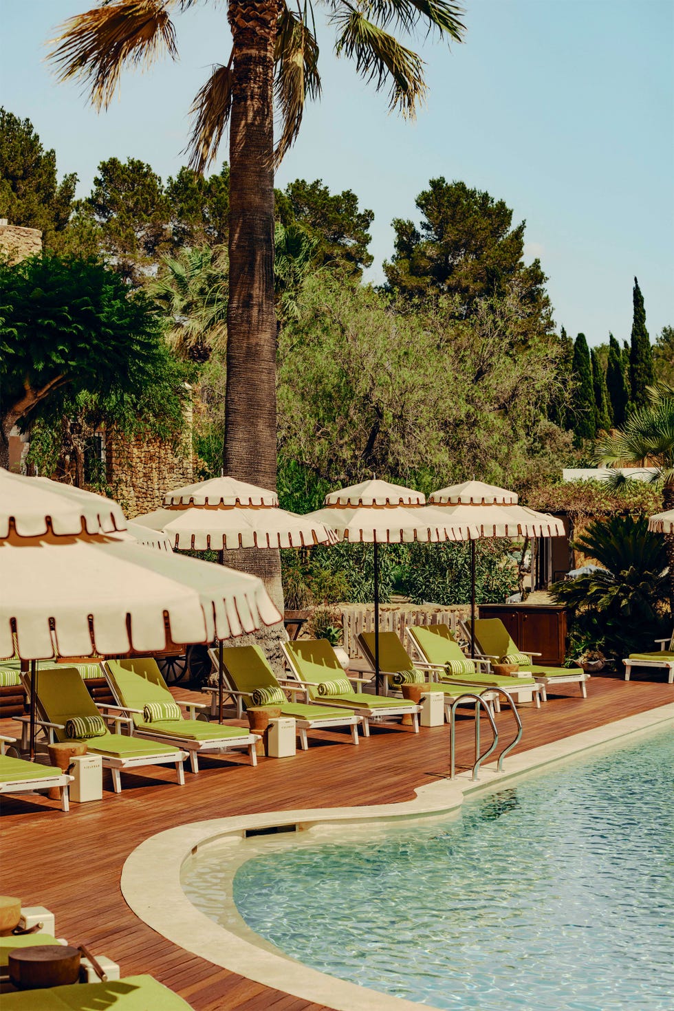 Swimming pool area with loungers and umbrellas.