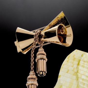 Elegant gold brooch featuring a bow design and tassel like elements