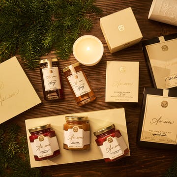 Gourmet food and candle gift collection displayed on a wooden surface. Gourmet food and candle gift collection displayed on a wooden surface.
