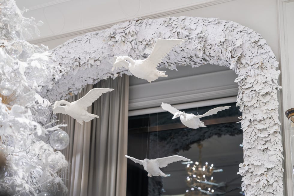 white plaster geese fly through the interior of bergdorf goodman.