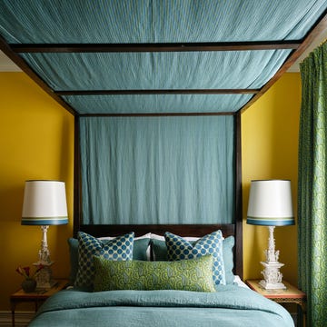 tommy smythe designed guest room with canopied bed dressed in blue and green linens