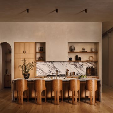 Modern kitchen with minimalist design, featuring a marble backsplash and wooden furniture.