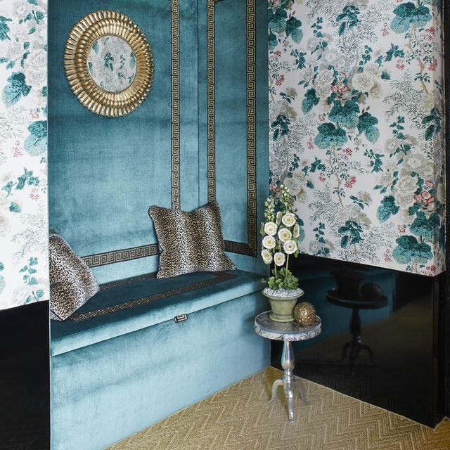 A-List 2024 - ELLE DECOR corner banquette swathed in ice blue velvet and black leopard accent pillows and a wallpaper with blue flowers
