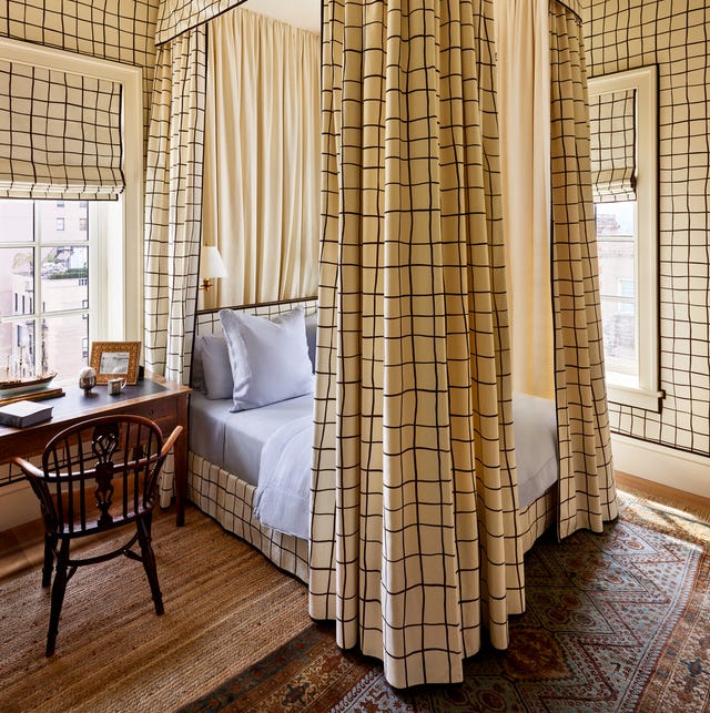 A-List 2024 - ELLE DECOR four poster bed with high cream curtains with large blue checks and matching roman shades and bedskirt and wallpaper