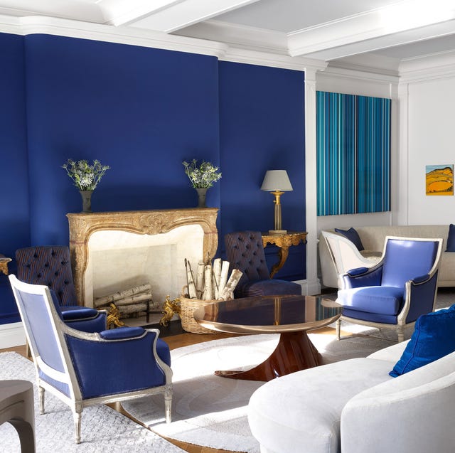 A-List 202 - ELLE DECOR a room with blue walls and matching chairs and white sofa and carpet and gilded tables with lamps