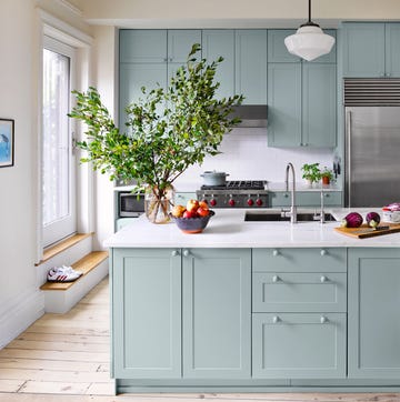 kitchen with light plank flooring and light greenish blue cabinetry and white countertops