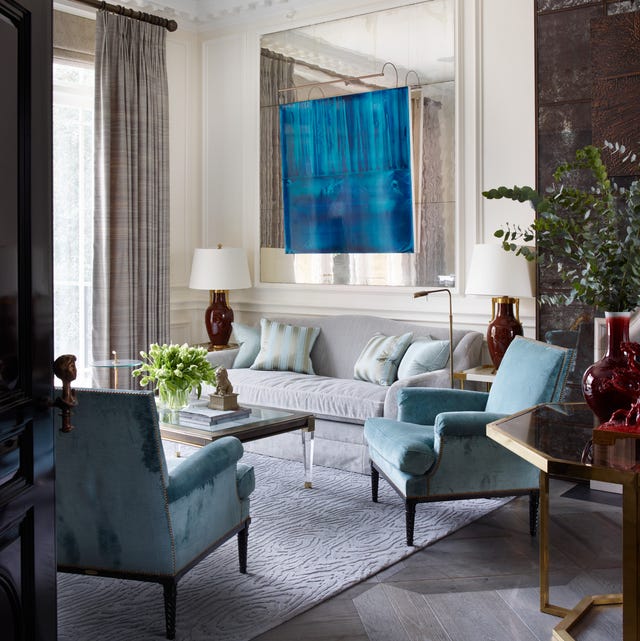 A-List 2024 - ELLE DECOR living room with large aqua bluish painting at center over a pale blue velvety sofa and two slightly darker blue chairs flanking a wood and lucite cocktail table