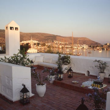 a rooftop with white buildings and a body of water in the background