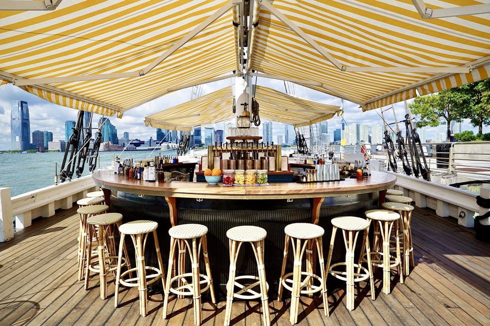 a bar setup on a boat with a city skyline in the background