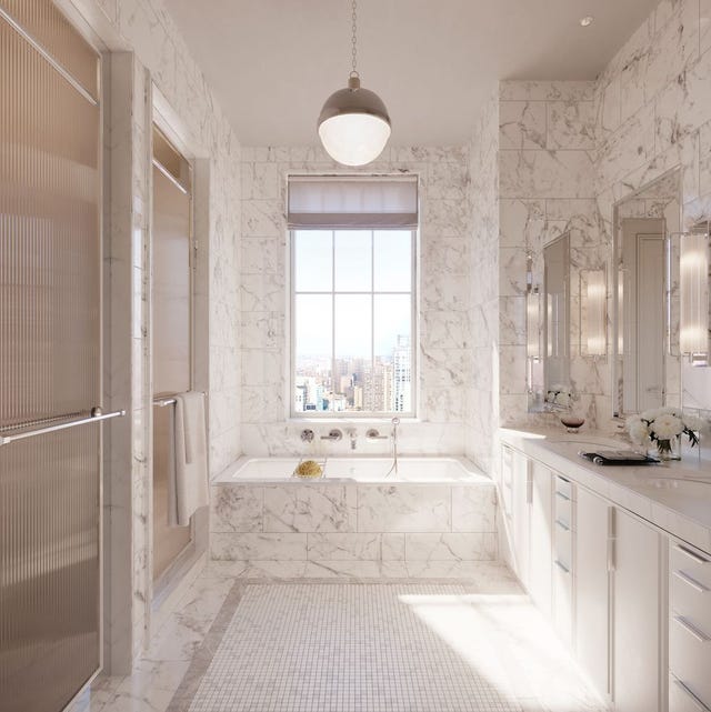 A-List 2024 - ELLE DECOR a white marble bathroom with a large window