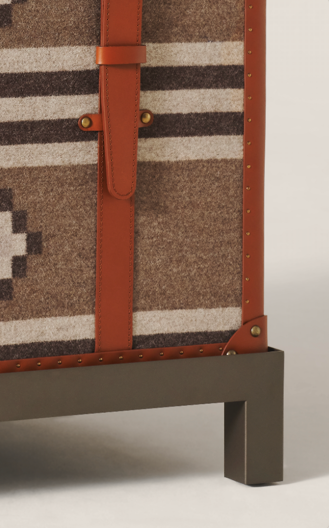 Storage trunk with fabric cover and leather accents.