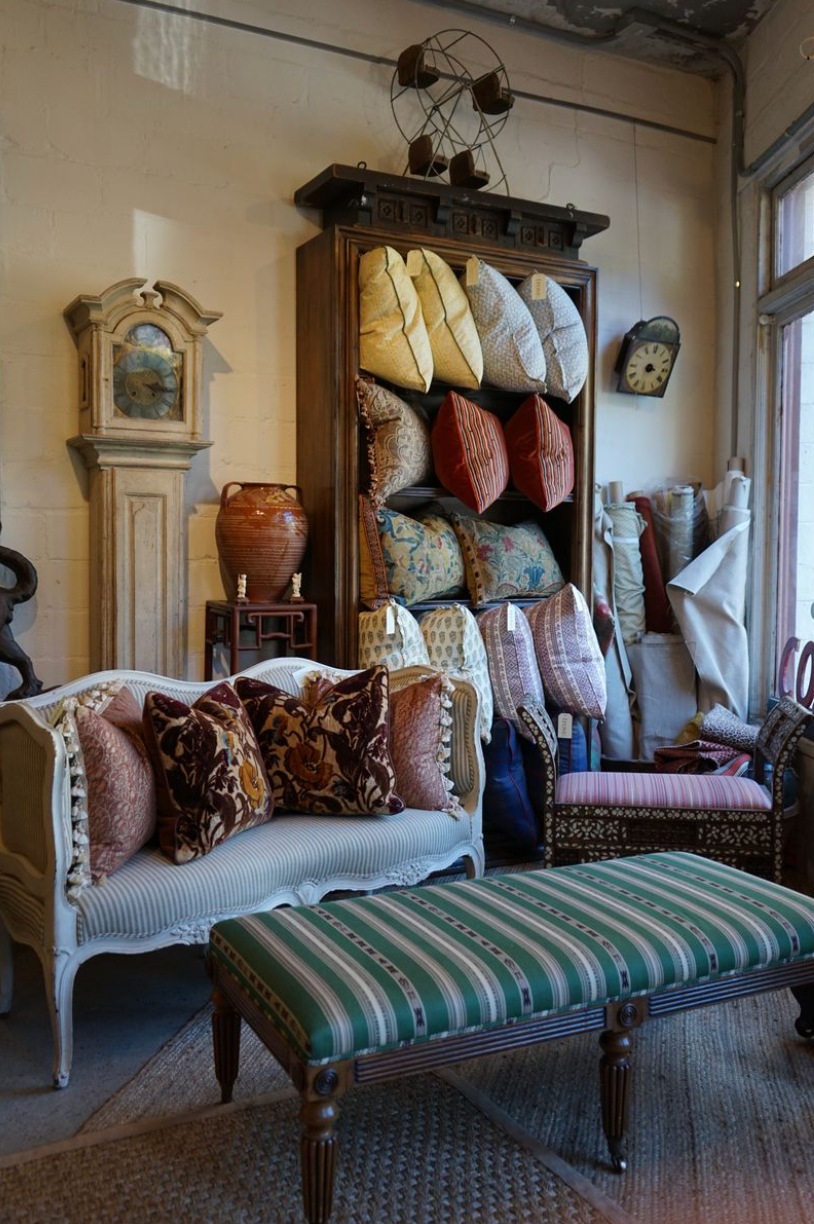 Interior decor featuring vintage furniture and assorted textiles.